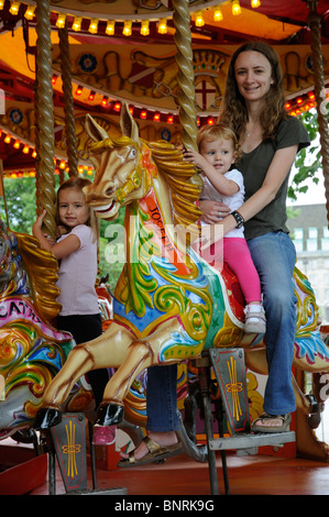 Mutter und Kinder reiten auf einem Messegelände fahren Stockfoto