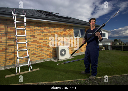 Qualifizierte Handwerker, die Installation von solar-Warmwasser-System zu einem Haus, Nelson, New Zealand, die Stadt mit der höchsten Sonnenscheinstunden Stockfoto