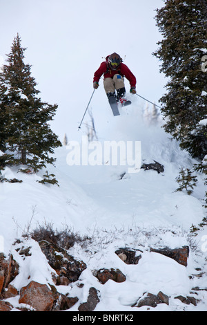 Ein männlicher Telemark-Skifahrer springt von einer Klippe in Bridger Bowl, Montana. Stockfoto