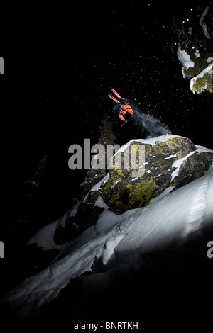 Eine männliche Telemark-Skifahrer-Front kehrt von einer Klippe in der Nacht in Montana. Stockfoto