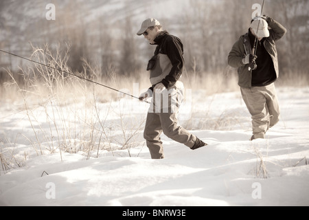 Zwei alte Freunde Fuß durch den Schnee im Winter am Fluss Provo in Utah zu fischen. Stockfoto