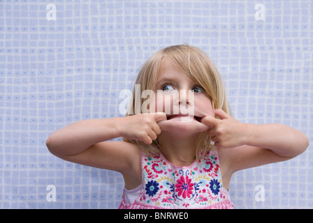 Kleine blonde Mädchen, das ein lustiges Gesicht. Stockfoto