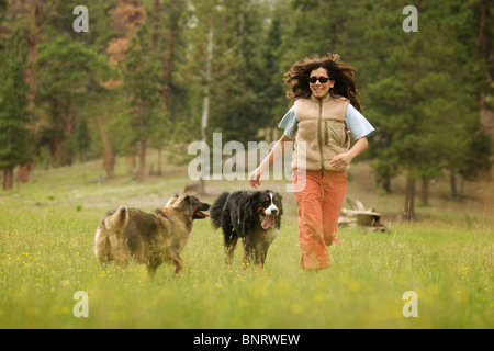 Frauen spielen mit ihrem Hund in den Bergen. Stockfoto