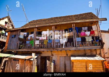 Bunte Wäsche hängen zum Trocknen auf dem Balkon eines zweistöckigen Hauses in Ambositra, im zentralen Hochland von Madagaskar Stockfoto