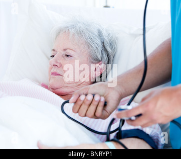 Kranke ältere Frau auf einem Krankenhausbett liegen Stockfoto