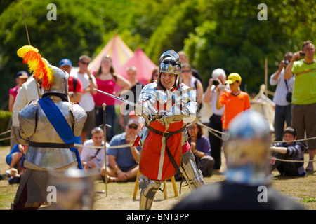 Gekleidet in authentischen Rüstungen und verwenden, die echte Schwerter Reenactor Duell als mittelalterliche Ritter auf ein mittelalterliches fest in Arundel gehalten Stockfoto