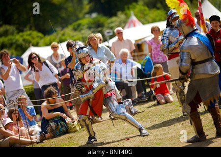 Gekleidet in authentischen Rüstungen und verwenden, die echte Schwerter Reenactor Duell als mittelalterliche Ritter auf ein mittelalterliches fest in Arundel gehalten Stockfoto