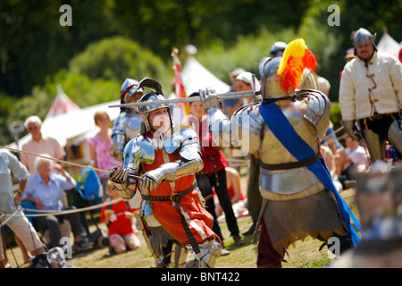 Gekleidet in authentischen Rüstungen und verwenden, die echte Schwerter Reenactor Duell als mittelalterliche Ritter auf ein mittelalterliches fest in Arundel gehalten Stockfoto