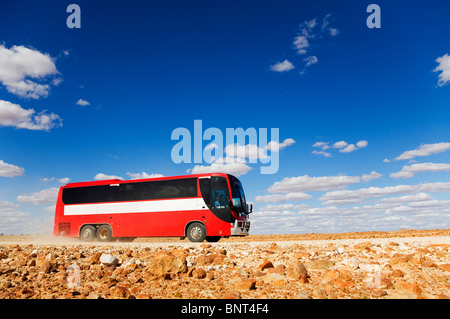 Ein Bus fährt auf einem Schotterweg im Outback von Queensland, in der Nähe von Birdsville, Queensland, Australien. Stockfoto