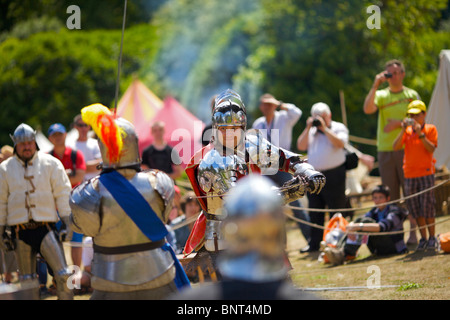 Gekleidet in authentischen Rüstungen und verwenden, die echte Schwerter Reenactor Duell als mittelalterliche Ritter auf ein mittelalterliches fest in Arundel gehalten Stockfoto