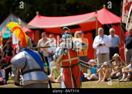 Gekleidet in authentischen Rüstungen und verwenden, die echte Schwerter Reenactor Duell als mittelalterliche Ritter auf ein mittelalterliches fest in Arundel gehalten Stockfoto