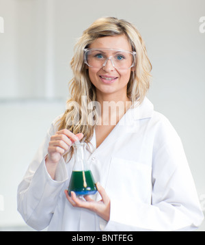 Frau in Lapcoat Blick auf Chemikalien Stockfoto