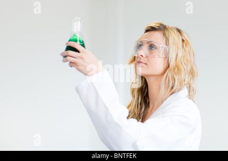 Frau in Lapcoat Blick auf Chemikalien Stockfoto