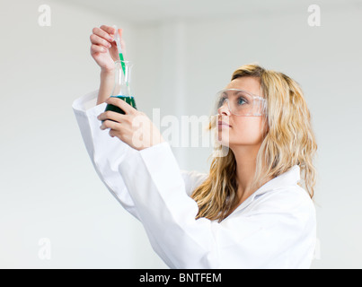 Frau in Lapcoat Blick auf Chemikalien Stockfoto