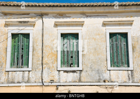 Drei Fenster mit grünen Fensterläden aus Holz zum lokalen wohnen in Kassiopi auf der griechischen Mittelmeer Insel von Corfu Griechenland GR Stockfoto