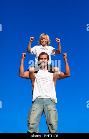 Starken Sohn auf seines Vaters Schultern sitzen Stockfoto