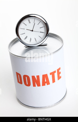 Spendenbox und Uhr, Konzept von "Zeit zu spenden" oder "Spenden Ihre Zeit". Stockfoto