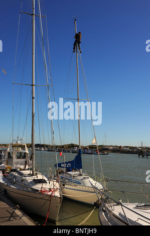 Mann, arbeitet auf einem Mast an Bord einer Yacht vor Anker im Hafen von Littlehampton West Sussex UK Stockfoto