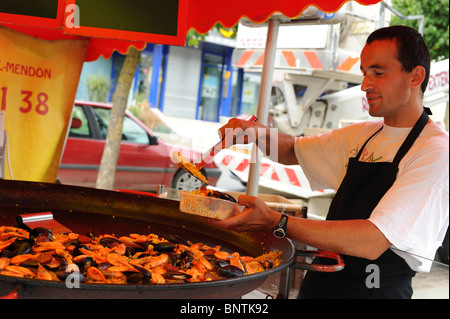 Mann Kochen Paella im Markt in der Bretagne, Frankreich. Stockfoto