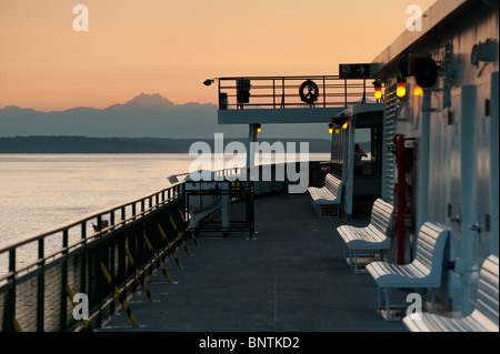 Eine US-Bundesstaat Washington Fähre macht seinen Weg von Bainbridge Island nach Downtown Seattle bei Sonnenuntergang. Olympic Mountains im Hintergrund. Stockfoto