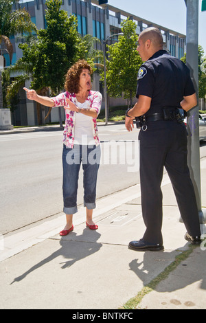 Eine Frau setzt sich mit Hispanic Polizist nachdem er für einen Verkehrsverstoß in Santa Ana, Kalifornien gestoppt. Stockfoto