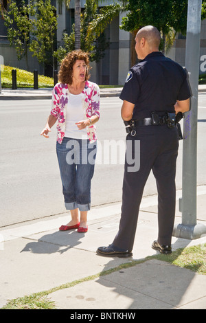 Eine Frau setzt sich mit Hispanic Polizist nachdem er für einen Verkehrsverstoß in Santa Ana, Kalifornien gestoppt. Stockfoto