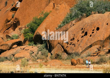 Touristen auf der Basis Fuß am Uluru (Ayers Rock). Uluru-Kata Tjuta National Park, Northern Territory, Australien. Stockfoto