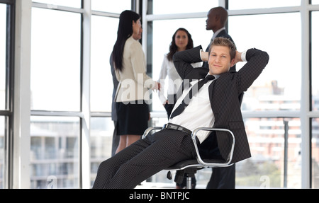 entspannende Manager im Büro mit Team im Hintergrund Stockfoto