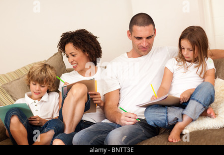 Begeisterte Familie sitzen auf einem sofa Stockfoto