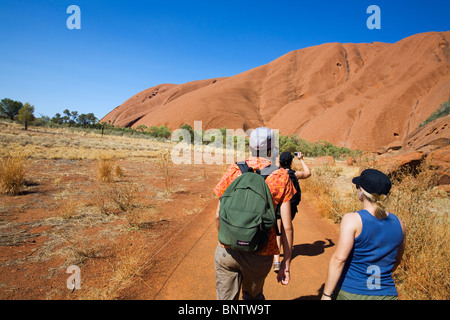 Wanderer auf der Basis des Uluru (Ayers Rock) Fuß. Uluru-Kata Tjuta National Park, Northern Territory, Australien. Stockfoto