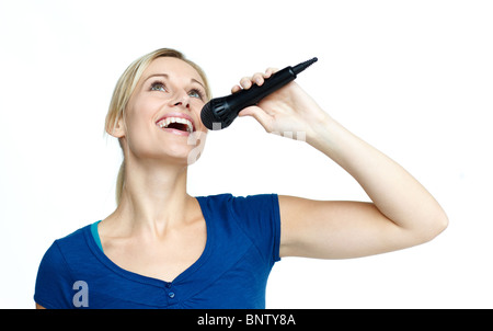 Frau singt auf ein Mikrofon vor weißem Hintergrund Stockfoto