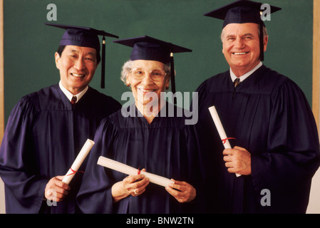 Drei Erwachsene Studenten tragen Graduierung Kleider Stockfoto