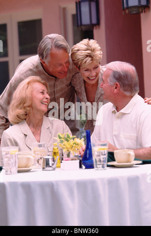 Zwei ältere Ehepaare, die Geselligkeit auf der Terrasse des Restaurants Stockfoto