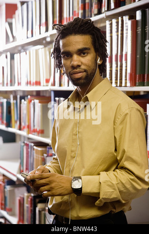 Menschen hören Musik mit Kopfhörern in Bibliothek Stockfoto