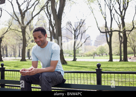 Mann sitzt auf einer Bank im Central Park Stockfoto