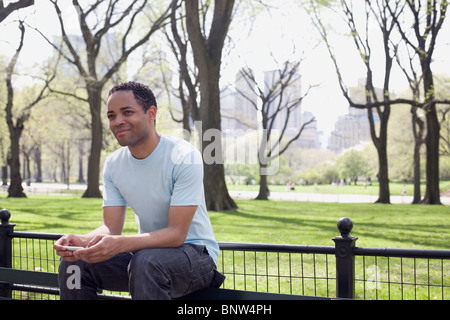 Mann sitzt auf einer Bank im Central Park Stockfoto