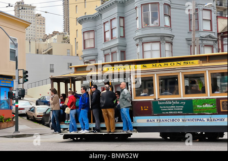Touristen-Passagiere fahren Oldtimer Kabel-a/k/a Trolley Auto oder Straßenbahn, San Francisco, Kalifornien, USA Powell und Mason Street Line Stockfoto