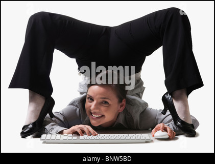 Geschäftsfrau, die ihren Körper verdrehen, während der Eingabe Stockfoto