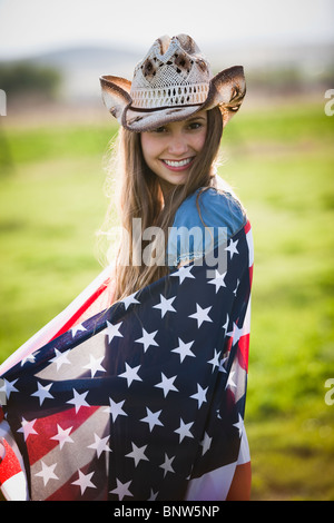 Schöne Cowgirl in amerikanische Flagge gehüllt Stockfoto