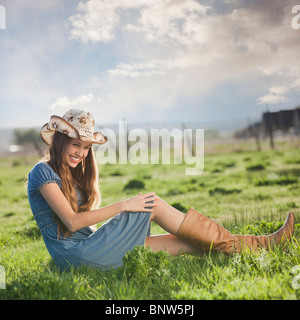 Cowgirl entspannend im Feld Stockfoto