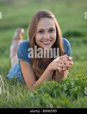 Schöne langhaarige Frau entspannen auf dem Rasen Stockfoto