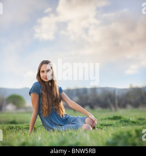 Schöne langhaarige Frau entspannen auf dem Rasen Stockfoto