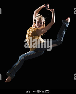 Blonde Frau tanzt beim Musikhören auf MP3-player Stockfoto