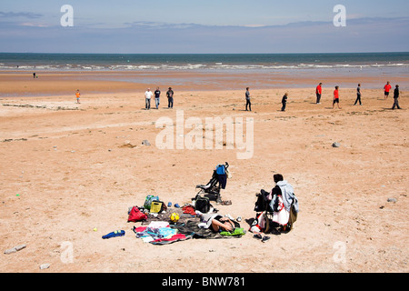 Familie entspannend am Strand, Benllech, Anglesey, North Wales, UK Stockfoto