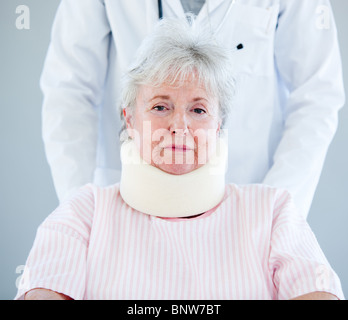 Porträt einer älteren Frau mit einer Halskrause, die auf einen Rollstuhl sitzend Stockfoto