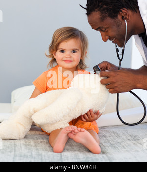 Kinder Arzt Prüfungen ein kleines Mädchen mit Stethoskop Stockfoto