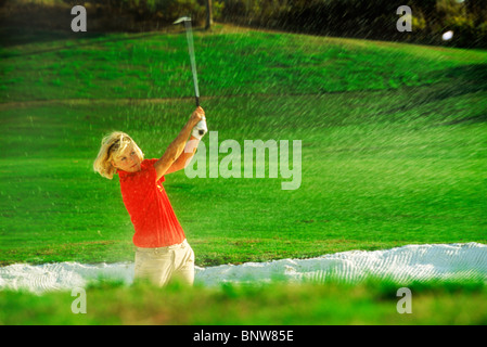 Frau Golfer Strahlen schoss aus Sandfang oder bunker Stockfoto