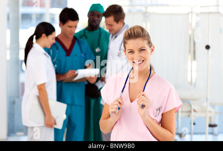 Porträt einer lächelnden Krankenschwester mit ihrem Team im Hintergrund Stockfoto