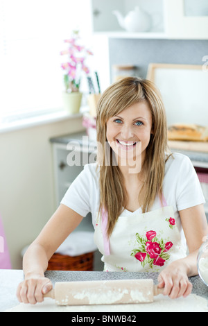 Porträt einer begeistert Frau einen Kuchen in der Küche vorbereiten Stockfoto