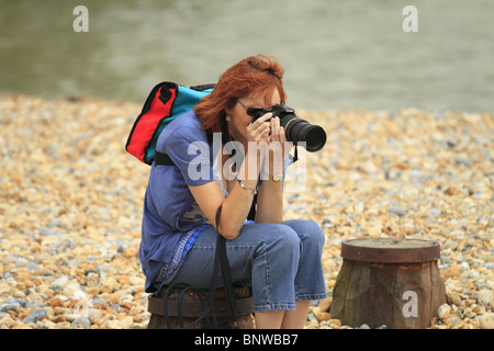 Eine Frau mit dem Fotografieren am Strand Eastbourne, East Sussex, England. Stockfoto